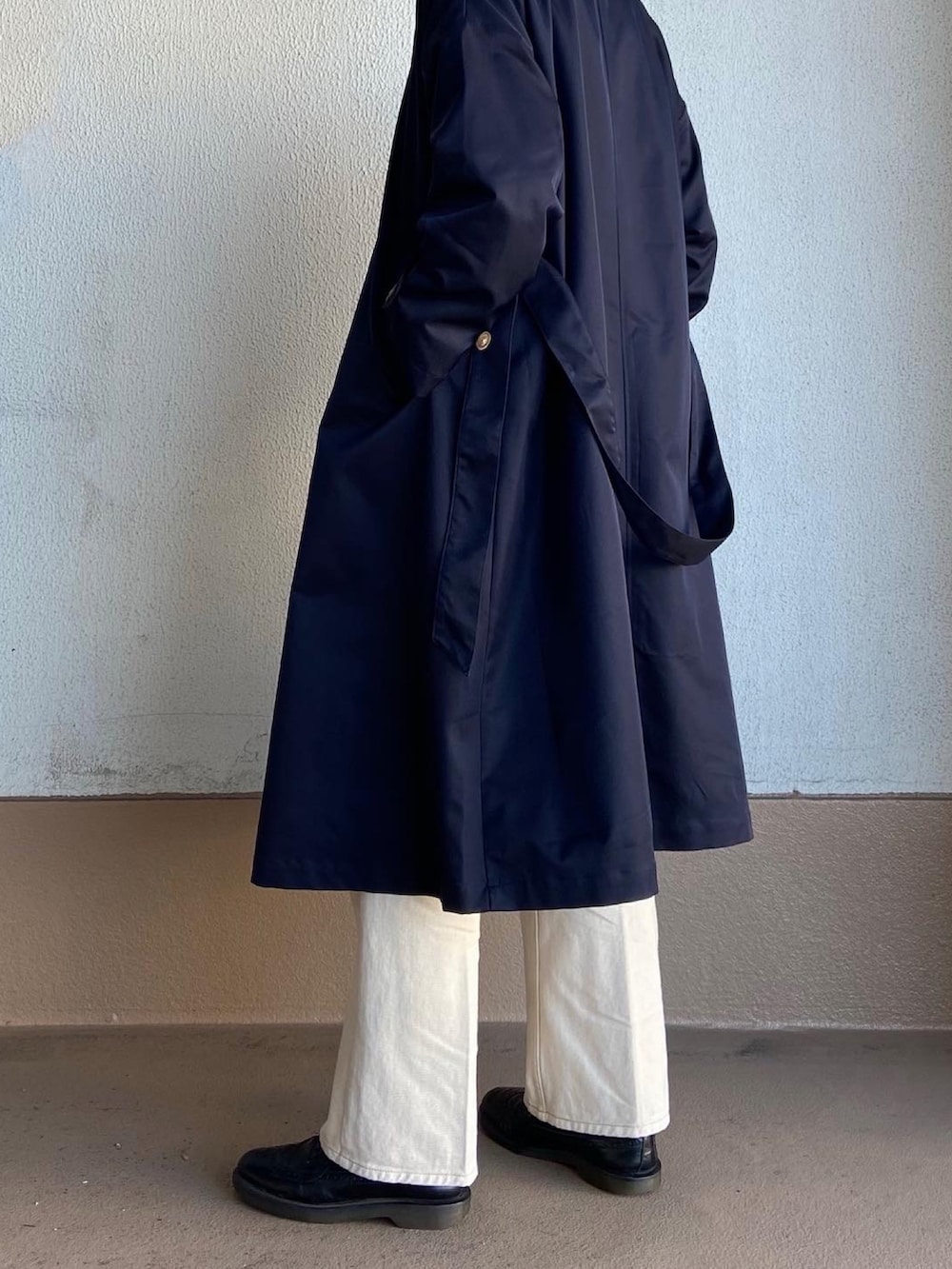 グレー系のスウェット、ホワイト系のデニムパンツ、ブルー系のステンカラーコートを着用したメンズの春コーディネートの4枚目の写真