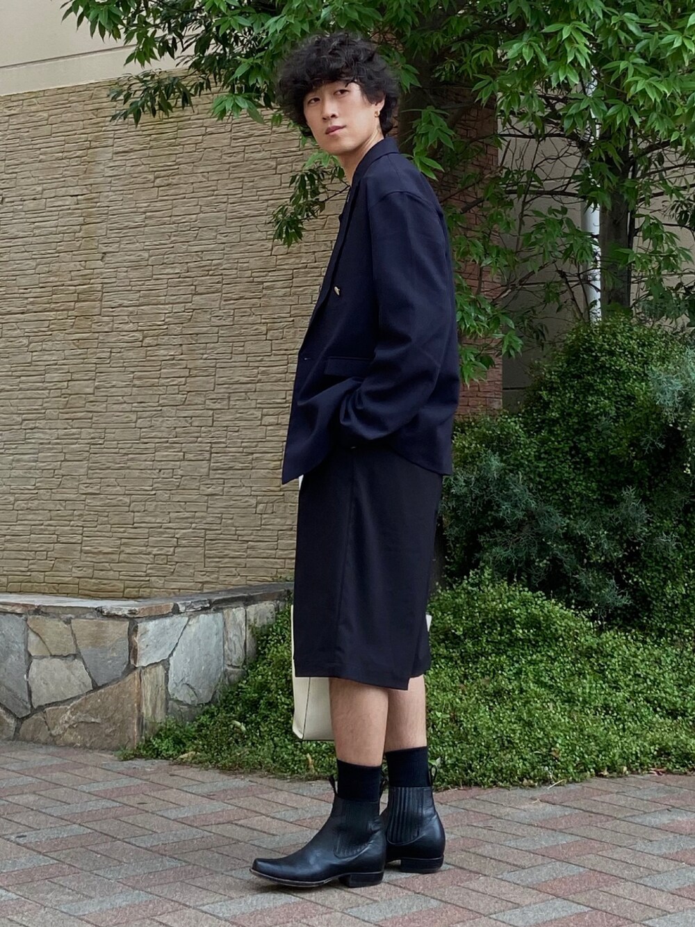 ホワイト系のショルダーバッグ、ブラック系のタンクトップ、ブルー系のテーラードジャケットを着用したメンズの夏コーディネートの3枚目の写真