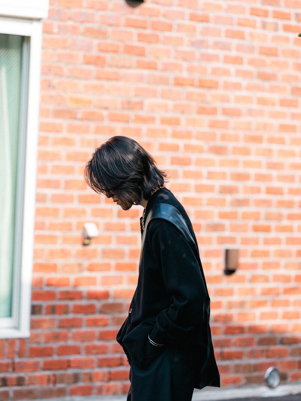 ブラック系のカーディガン/ボレロ、ブラック系のショルダーバッグを着用したメンズの秋コーディネートの3枚目の写真