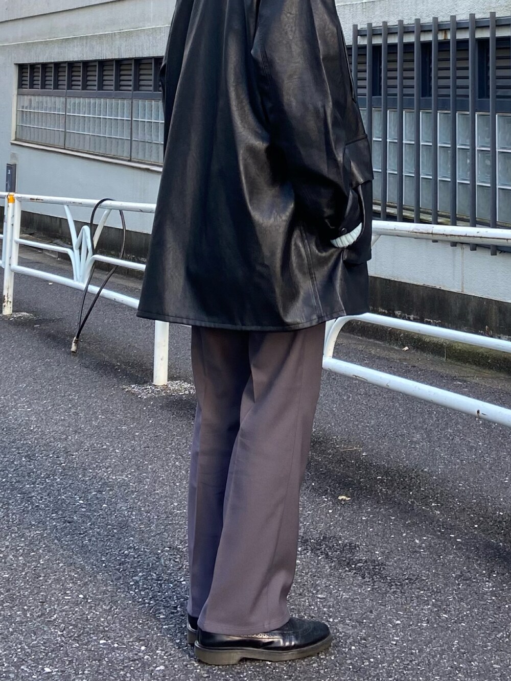 ブラック系のカバーオール、ブラック系のスラックス、ブルー系のニット/セーターを着用したメンズの冬コーディネートの2枚目の写真