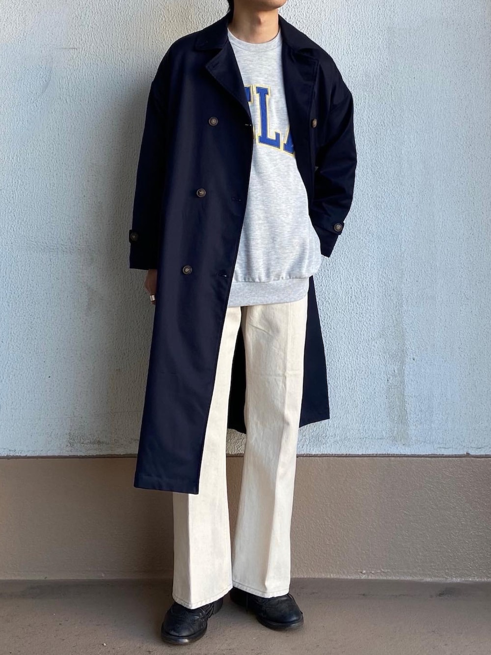 グレー系のスウェット、ホワイト系のデニムパンツ、ブルー系のステンカラーコートを着用したメンズの春コーディネートの3枚目の写真