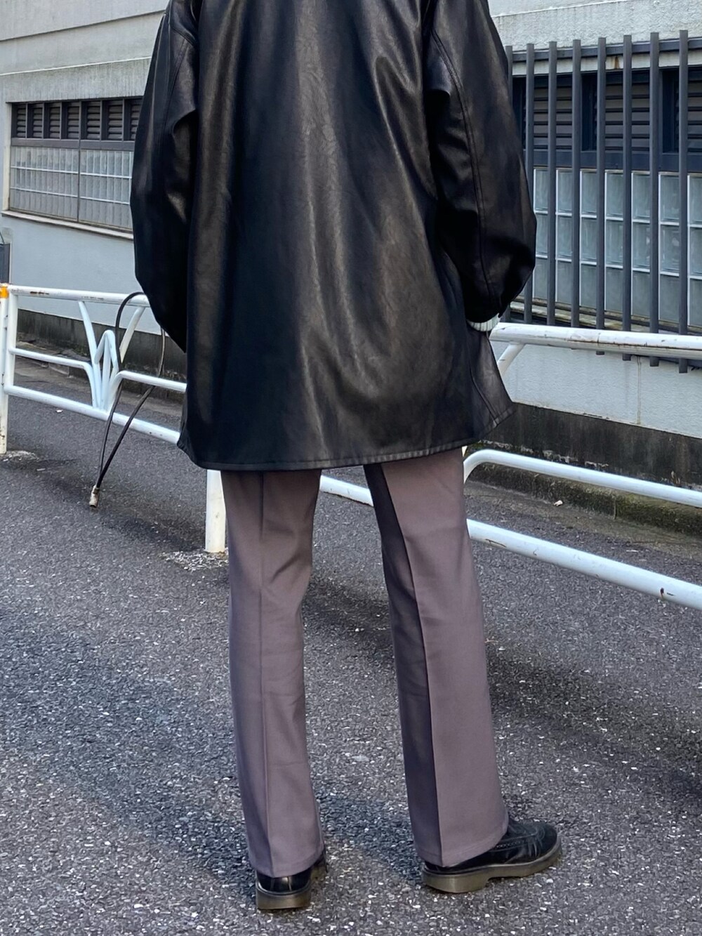 ブラック系のカバーオール、ブラック系のスラックス、ブルー系のニット/セーターを着用したメンズの冬コーディネートの3枚目の写真