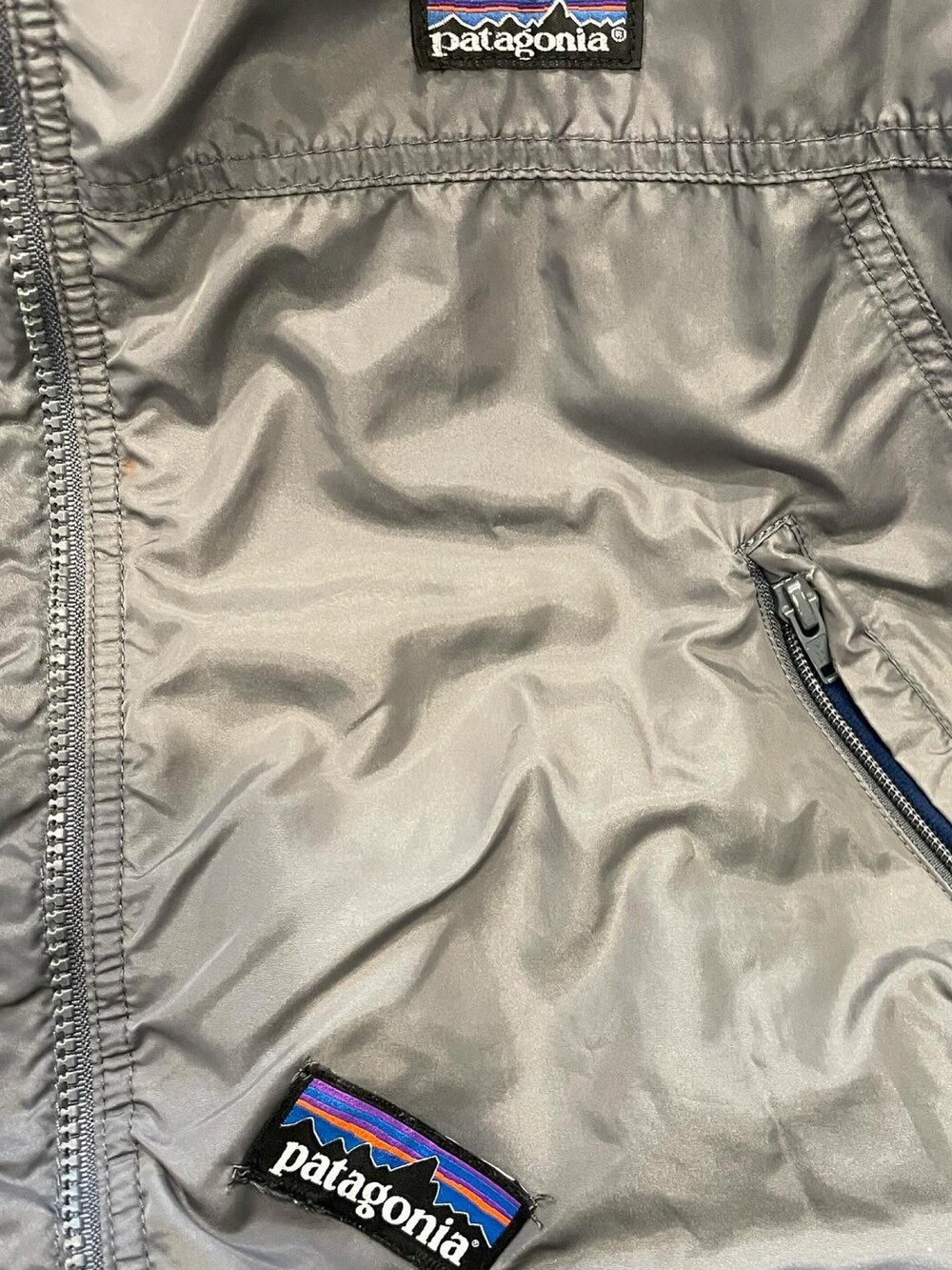 グレー系のナイロンジャケット、グリーン系のカーゴパンツを着用したメンズの冬コーディネートの2枚目の写真