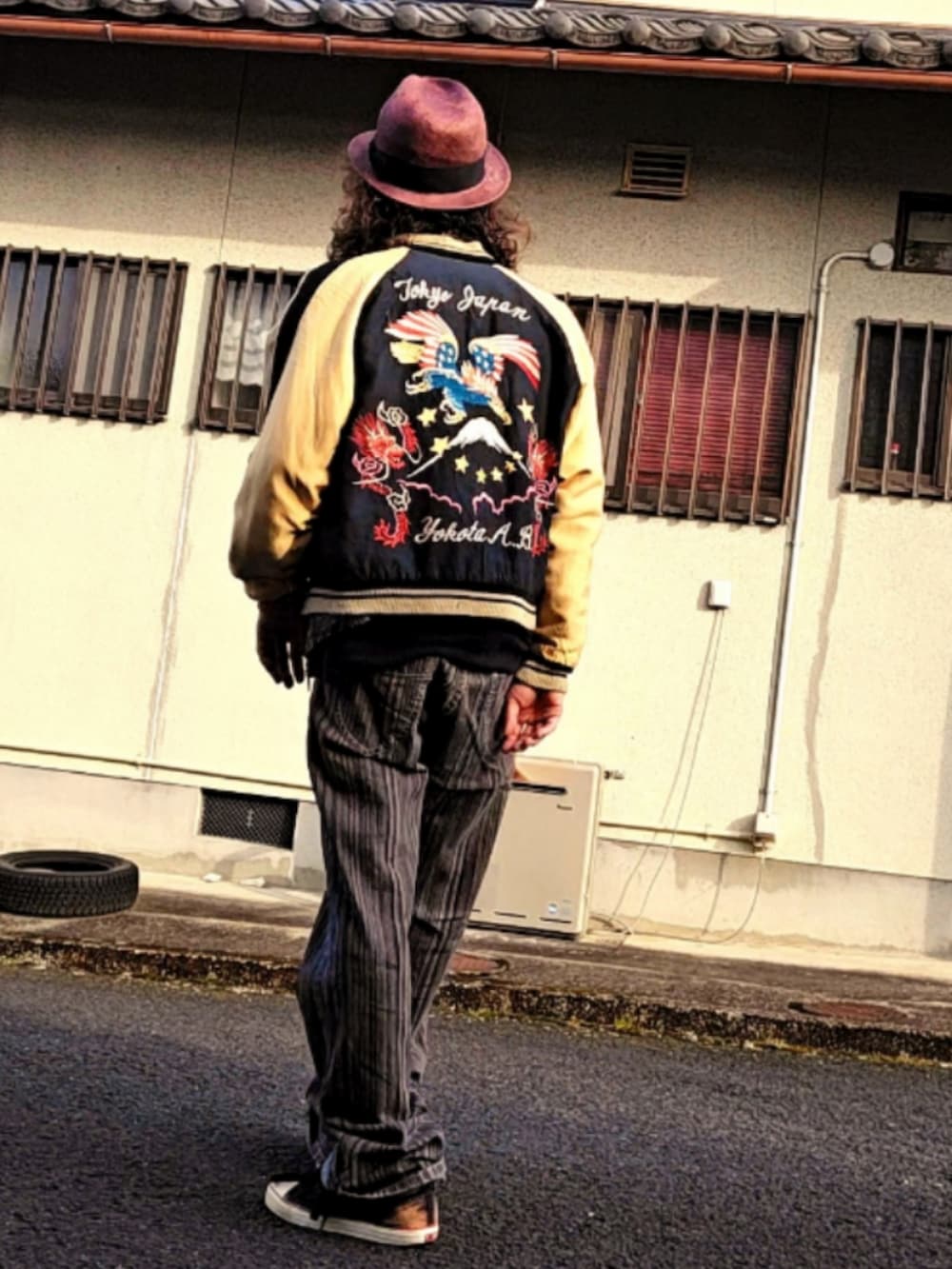 ブラウン系のパンツ、ブラック系のスニーカー、ブラック系のベストを着用したメンズの春コーディネートの2枚目の写真