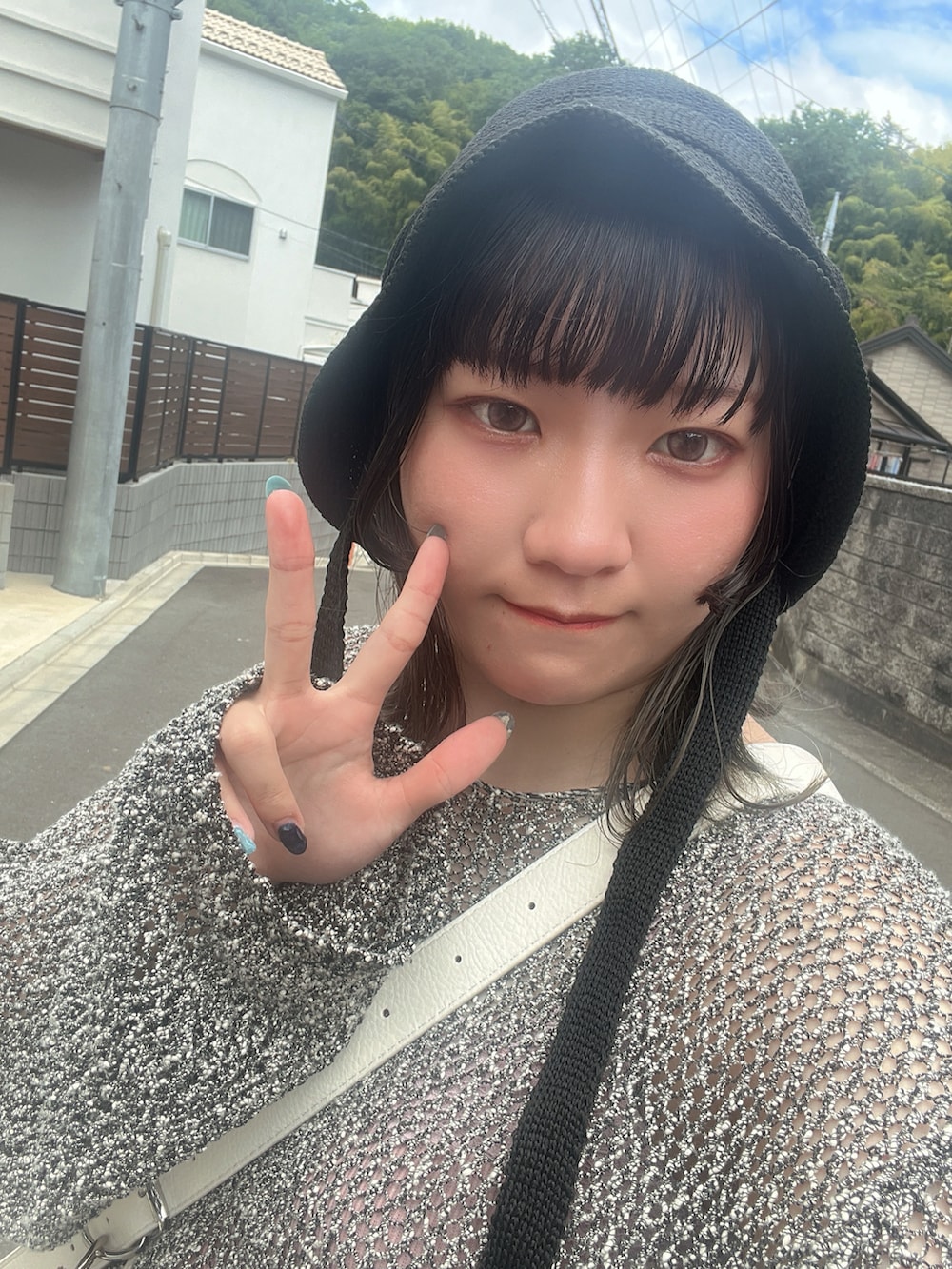 グリーン系のシャツ/ブラウス、ベージュ系のスカート、ブラック系のキャップを着用したレディースの春コーディネートの2枚目の写真