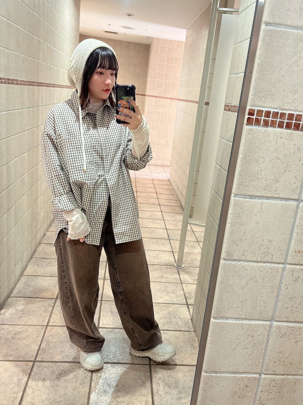 ホワイト系のTシャツ/カットソー、ブラウン系のシャツ/ブラウス、グレー系のスニーカーを着用したレディースの春コーディネートの2枚目の写真