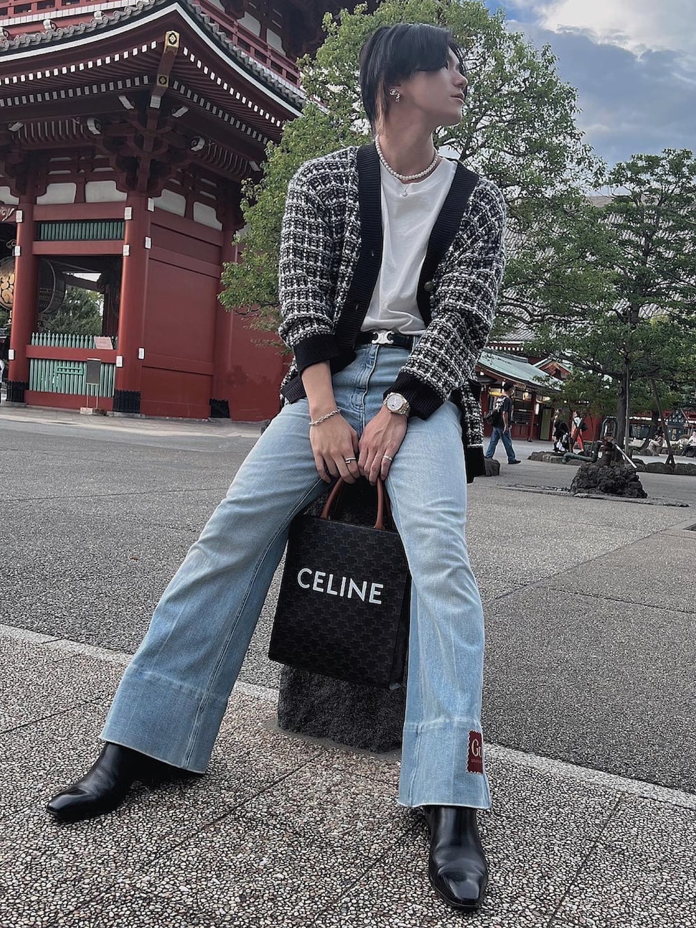 ブラック系のカーディガン/ボレロ、ブラック系のバッグ、ブルー系のデニムパンツを着用したメンズの秋コーディネートの2枚目の写真