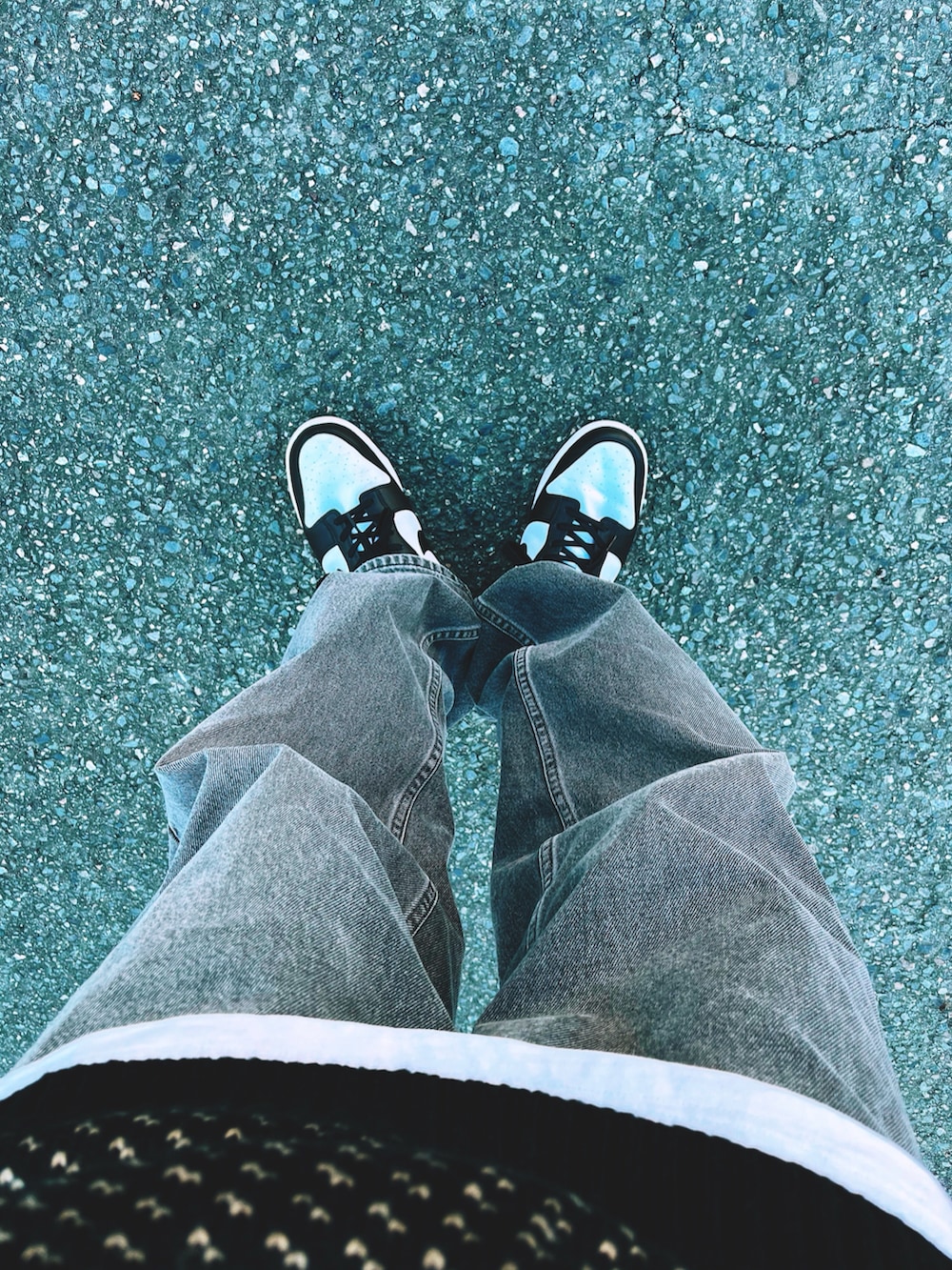 ブラック系のニット/セーター、ブラック系のデニムパンツ、ブラック系のスニーカーを着用したメンズの冬コーディネートの3枚目の写真