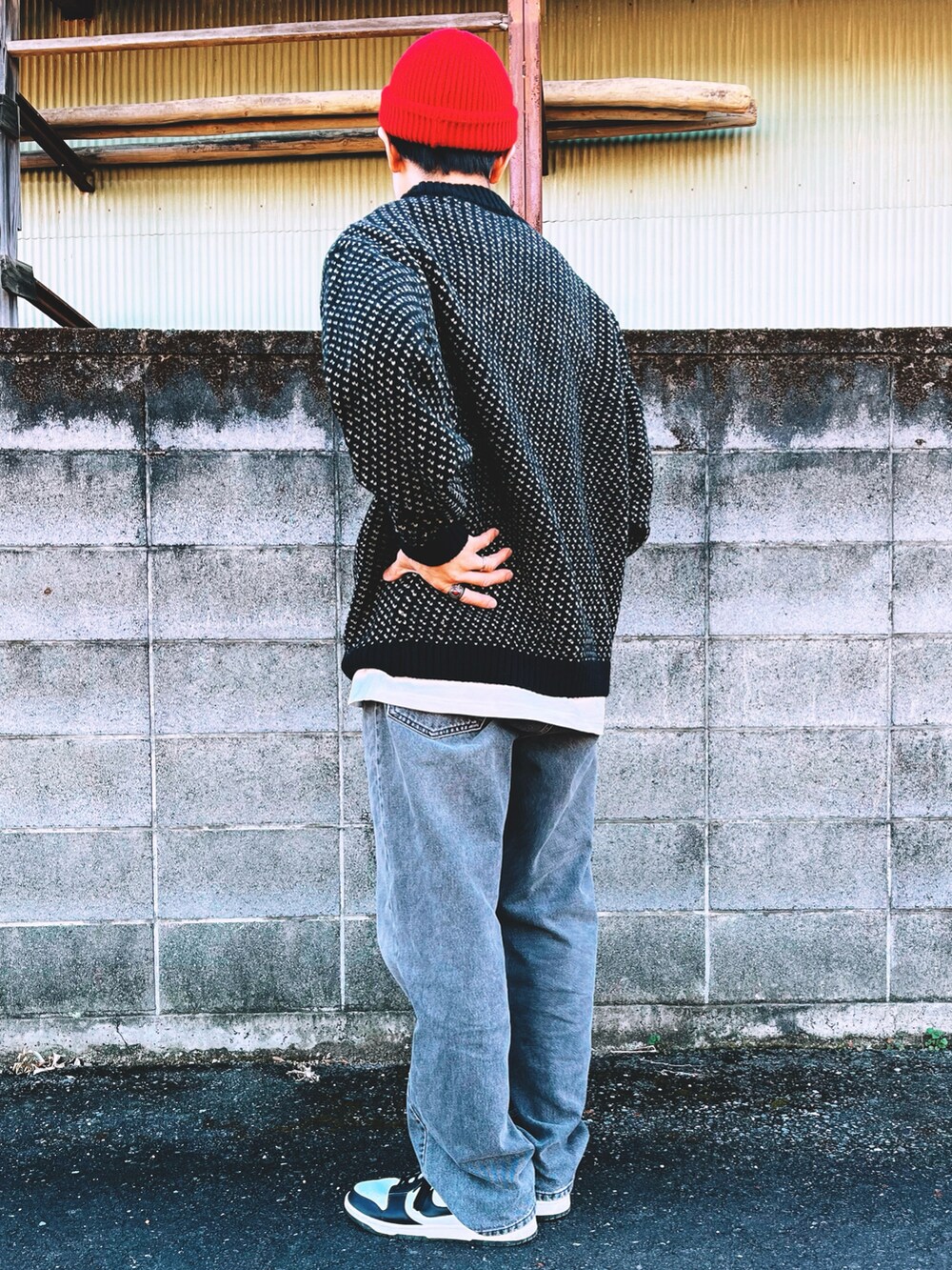 ブラック系のニット/セーター、ブラック系のデニムパンツ、ブラック系のスニーカーを着用したメンズの冬コーディネートの2枚目の写真