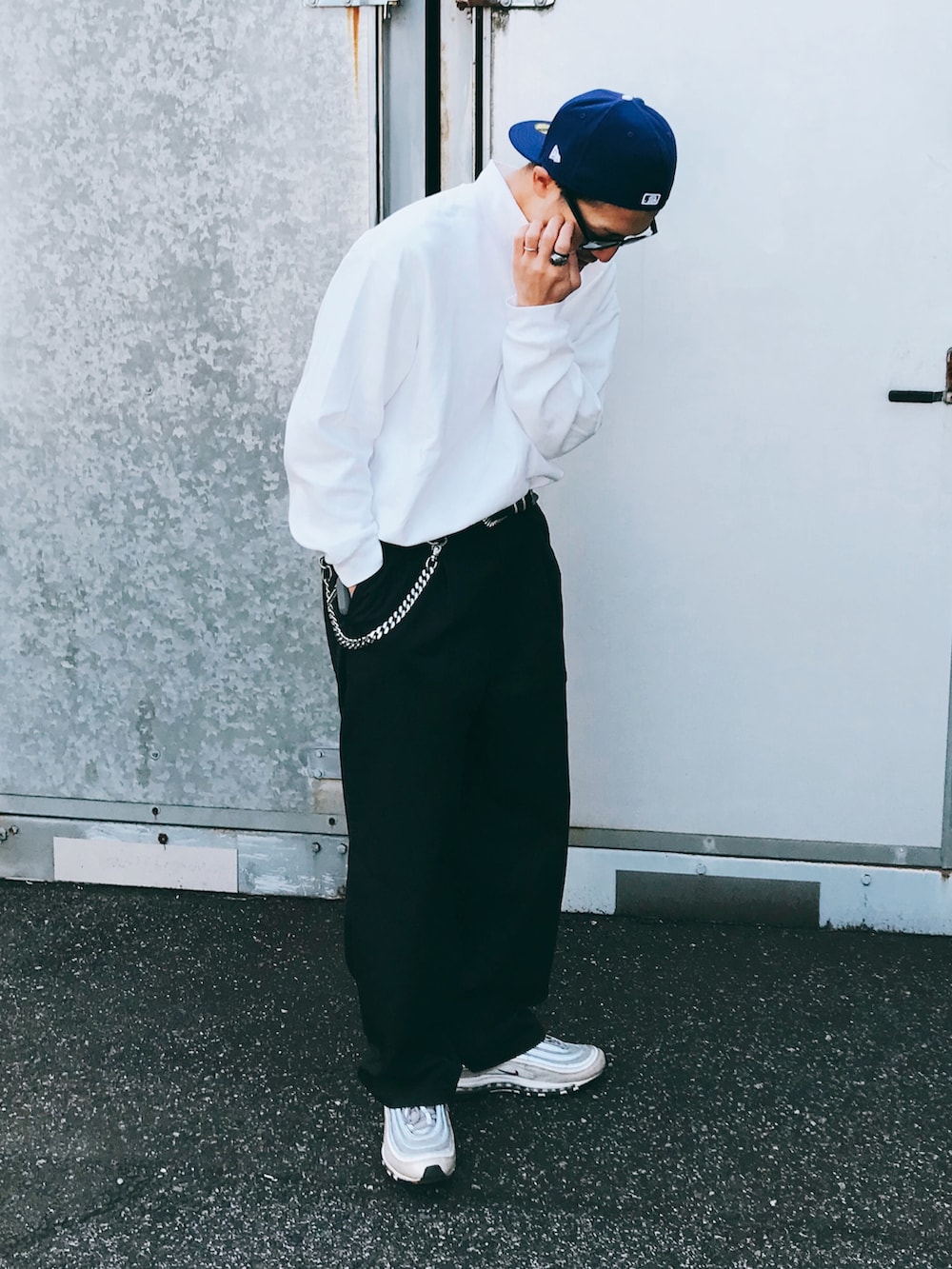 ホワイト系のトップス、ブラック系のパンツ、シルバー系のスニーカーを着用したメンズの秋コーディネートの2枚目の写真