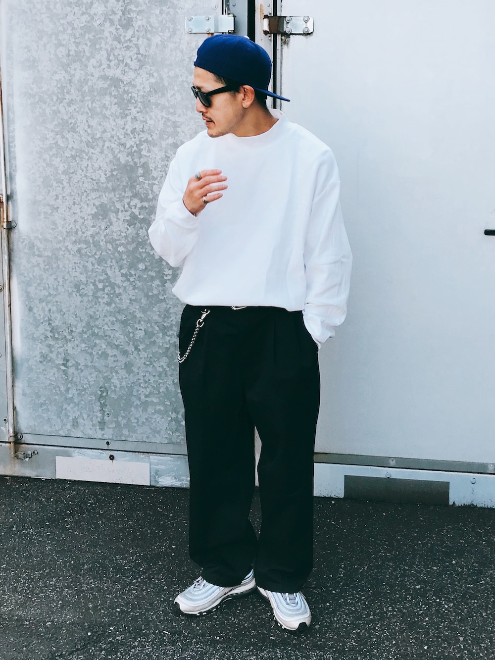 ホワイト系のトップス、ブラック系のパンツ、シルバー系のスニーカーを着用したメンズの秋コーディネートの3枚目の写真