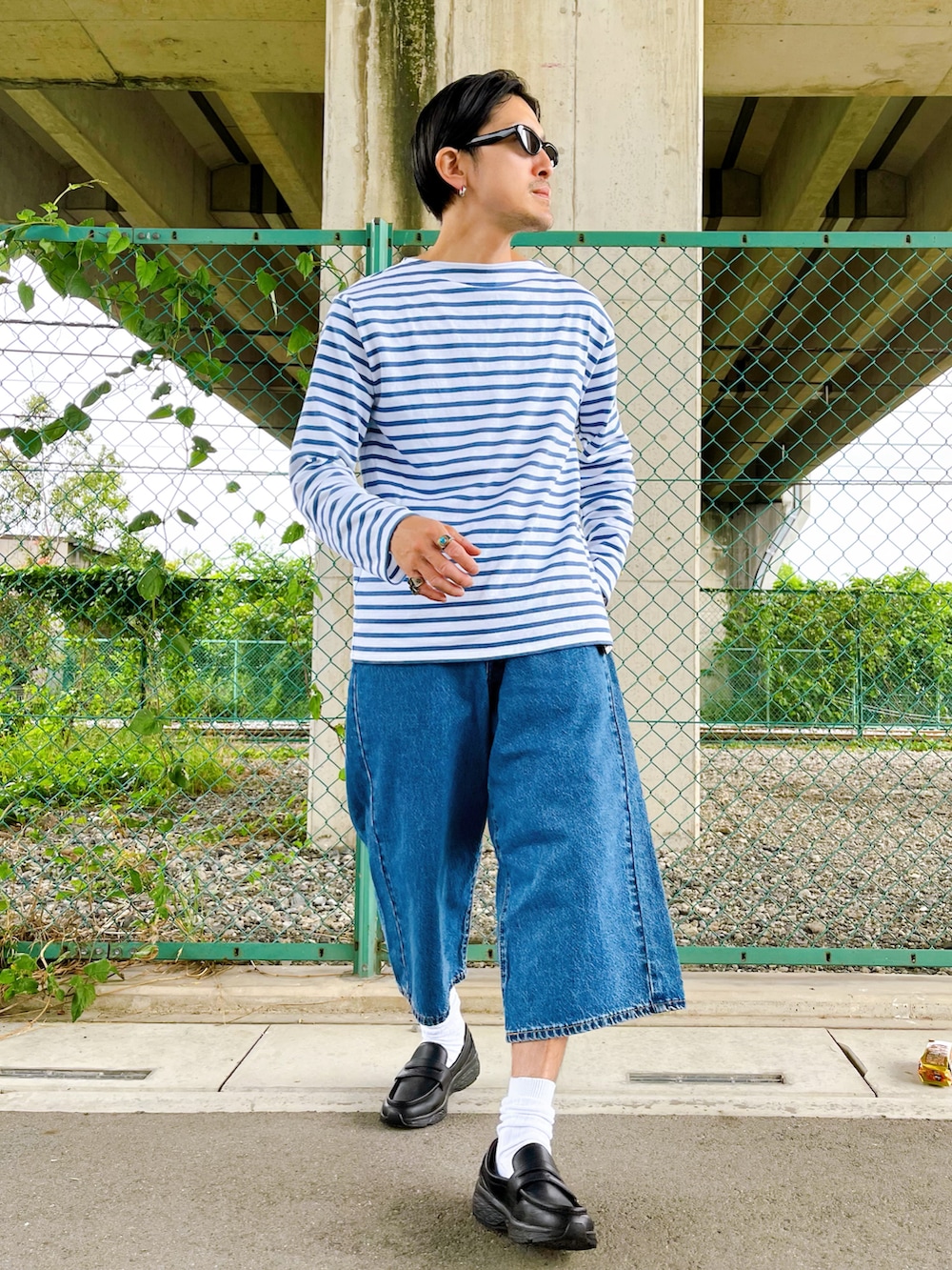 ブルー系のデニムパンツ、ホワイト系のTシャツ/カットソー、ブラック系のローファーを着用したメンズの夏コーディネートの2枚目の写真