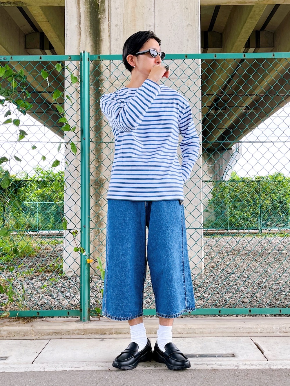 ブルー系のデニムパンツ、ホワイト系のTシャツ/カットソー、ブラック系のローファーを着用したメンズの夏コーディネートの3枚目の写真