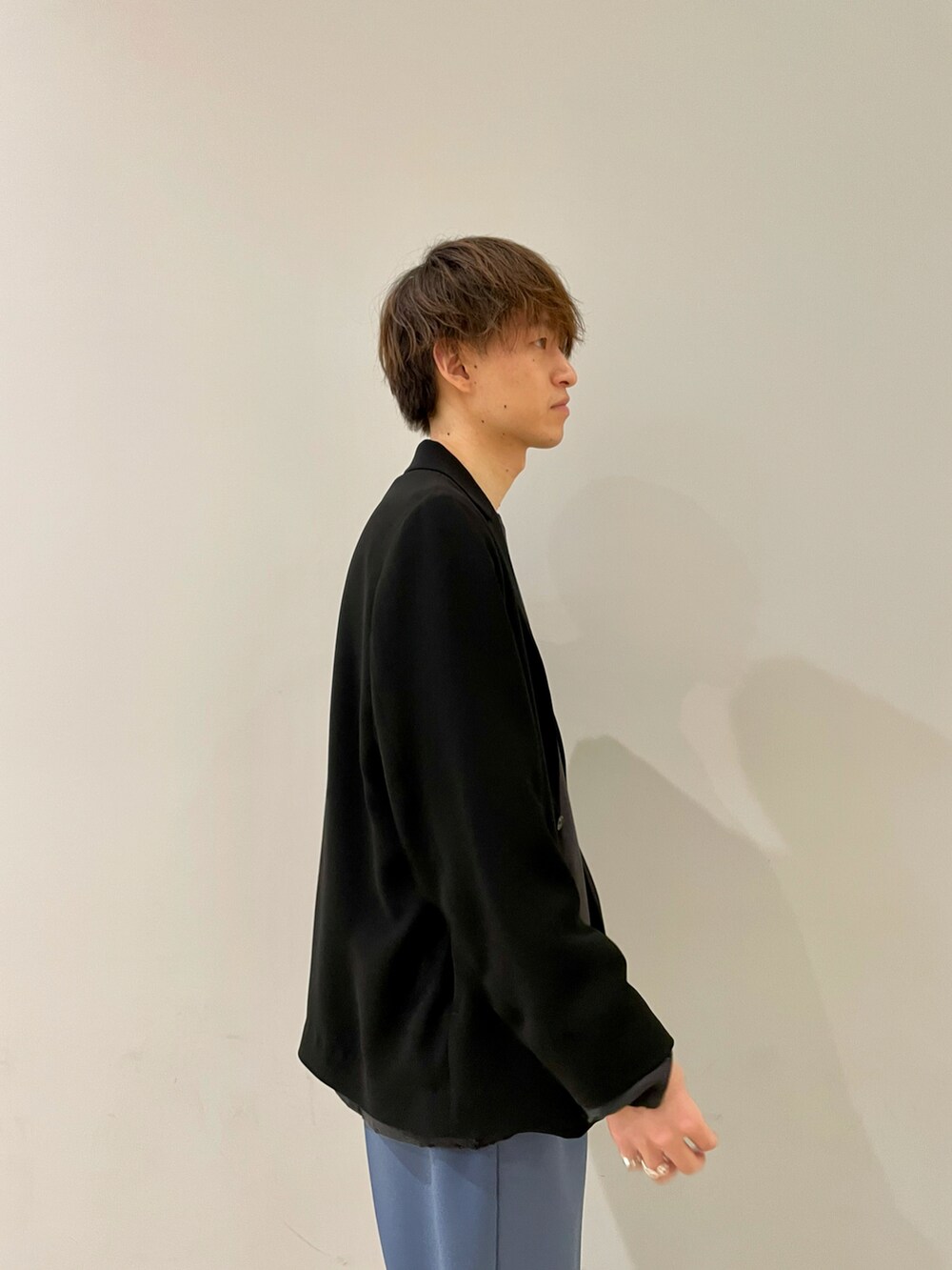 ブラック系のテーラードジャケット、ブルー系のスラックス、ブラック系のその他を着用したメンズの春コーディネートの2枚目の写真