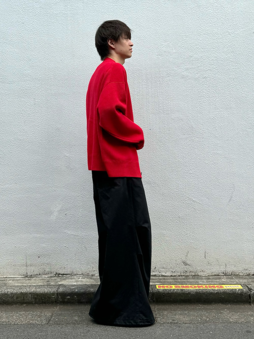 レッド系のニット/セーター、ブラック系のパンツ、ブラック系のその他を着用したメンズの秋コーディネートの2枚目の写真