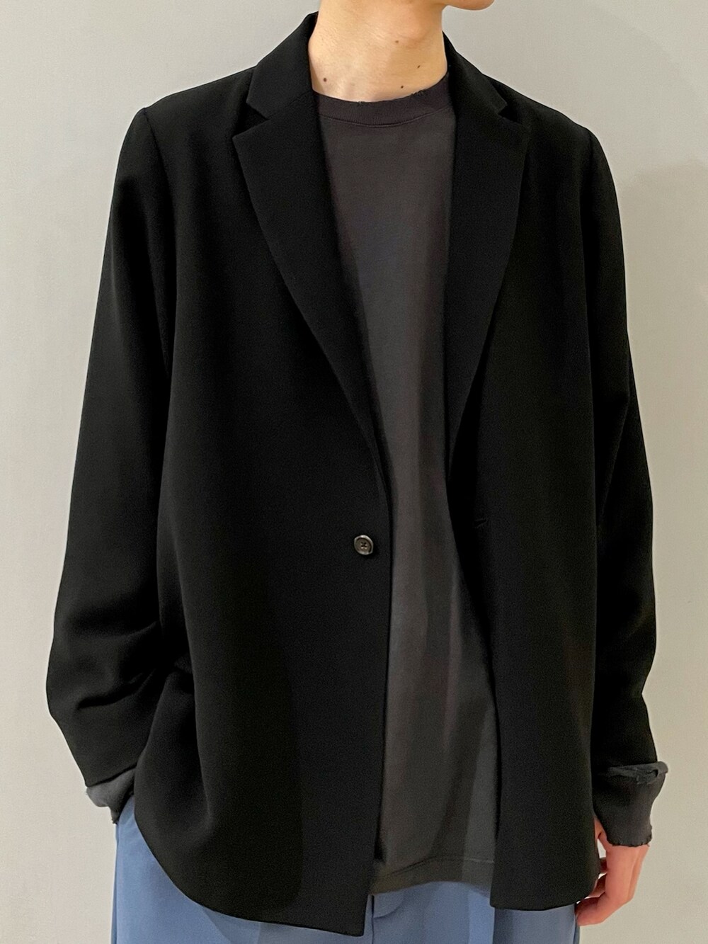 ブラック系のテーラードジャケット、ブルー系のスラックス、ブラック系のその他を着用したメンズの春コーディネートの3枚目の写真