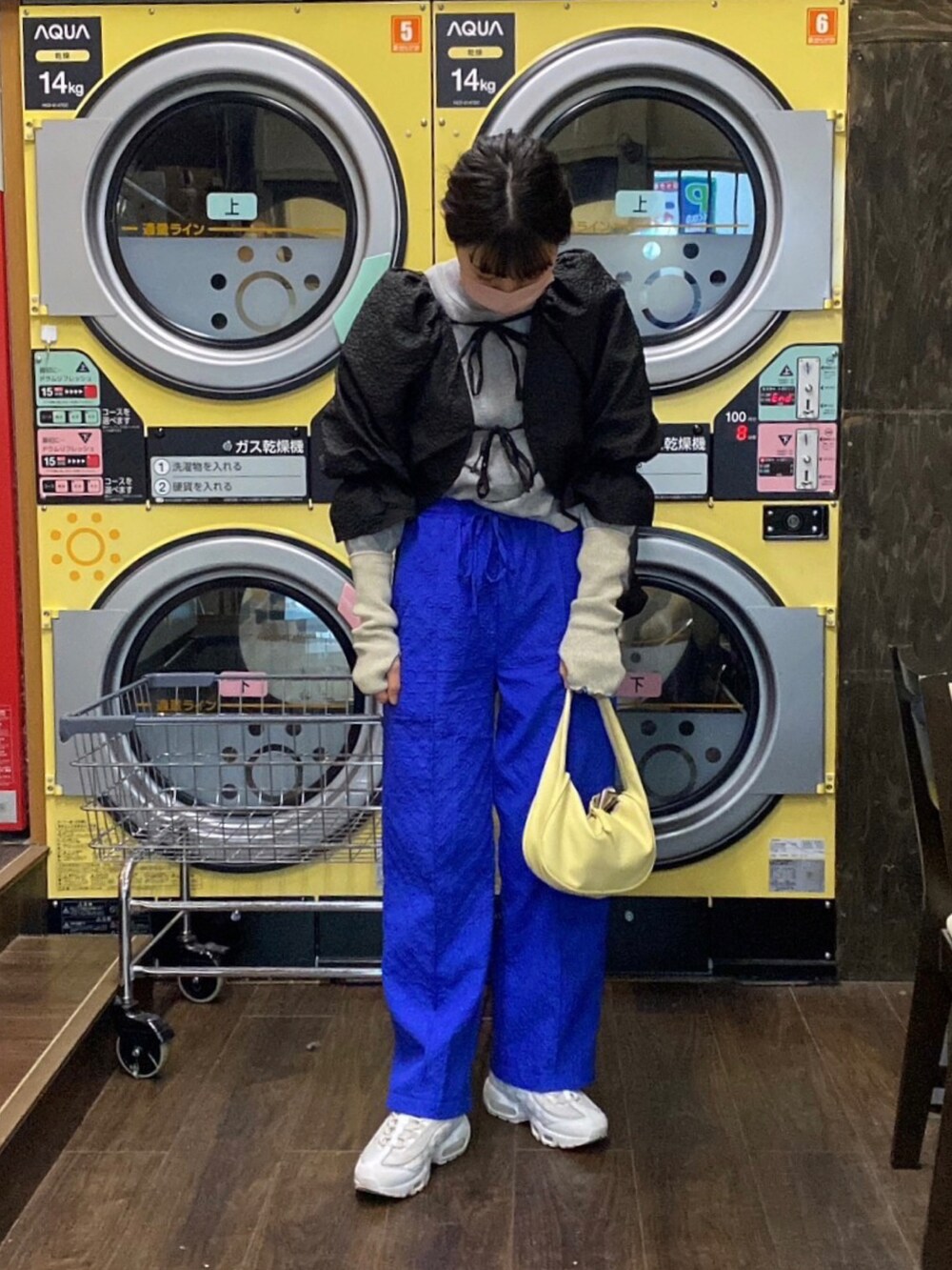 ブルー系のパンツ、ブラック系のカーディガン/ボレロを着用したレディースの冬コーディネートの2枚目の写真