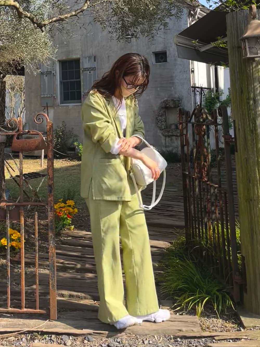 グリーン系のパンツ、グリーン系のテーラードジャケット、ホワイト系のTシャツ/カットソーを着用したレディースの春コーディネートの2枚目の写真