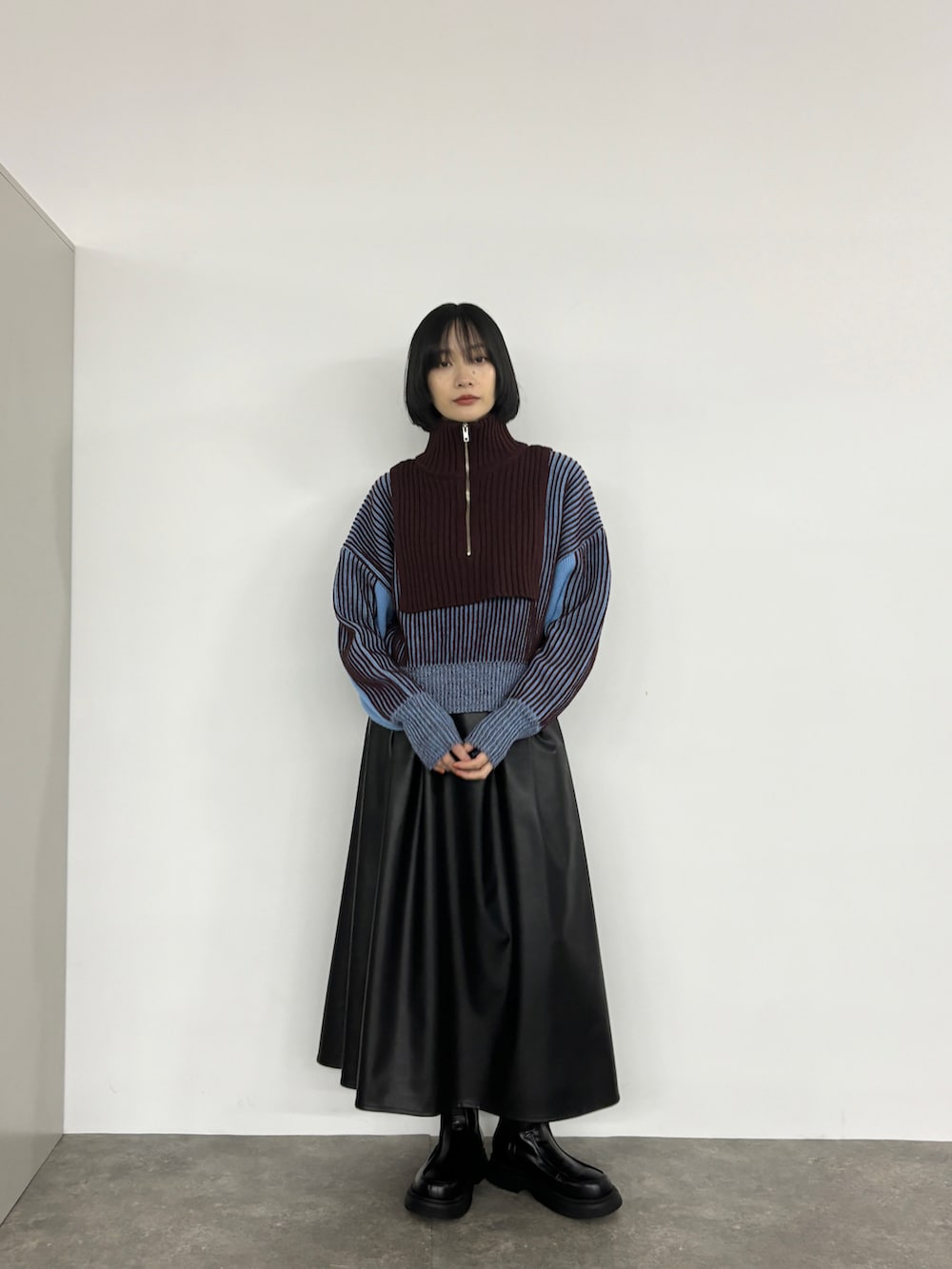 ブルー系のニット/セーター、ブラック系のブーツを着用したレディースの夏コーディネートの3枚目の写真