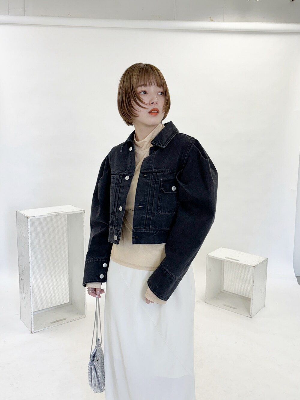 ブラック系のデニムジャケット、シルバー系のショルダーバッグを着用したレディースの冬コーディネートの2枚目の写真