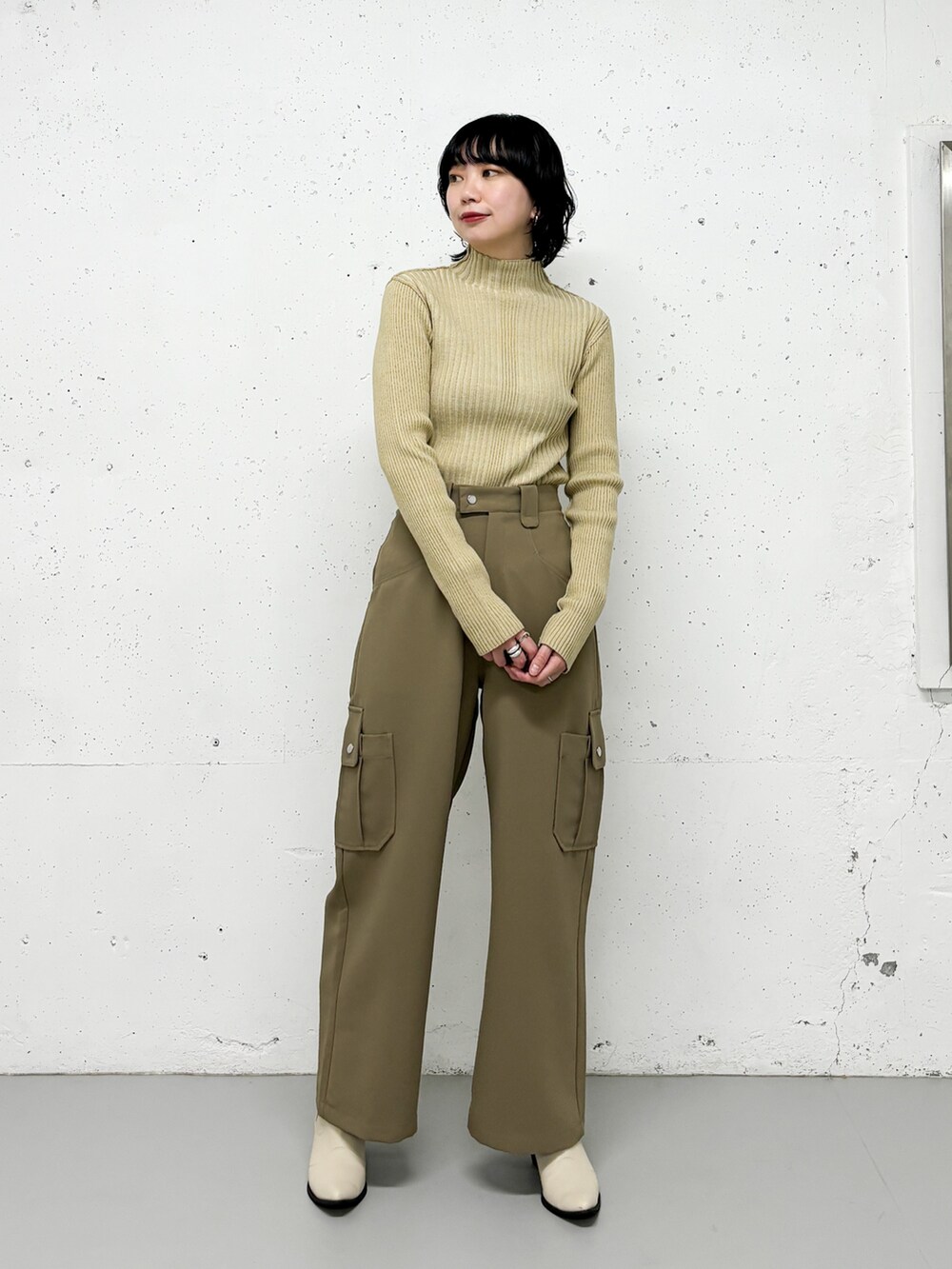 ベージュ系のニット/セーター、グリーン系のその他パンツ、オレンジ系のカーディガン/ボレロを着用したレディースの冬コーディネートの3枚目の写真