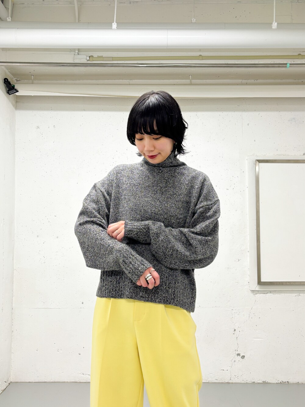 グレー系のニット/セーター、イエロー系のその他パンツを着用したレディースの冬コーディネートの2枚目の写真