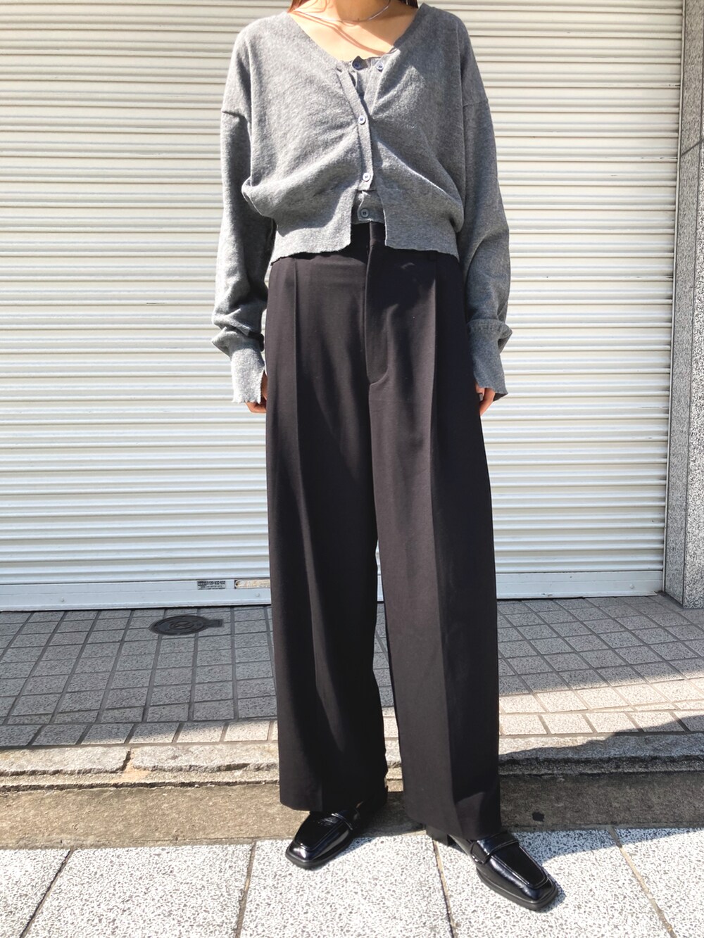 グレー系のカーディガン/ボレロ、ブラック系のスラックスを着用したレディースの秋コーディネートの3枚目の写真