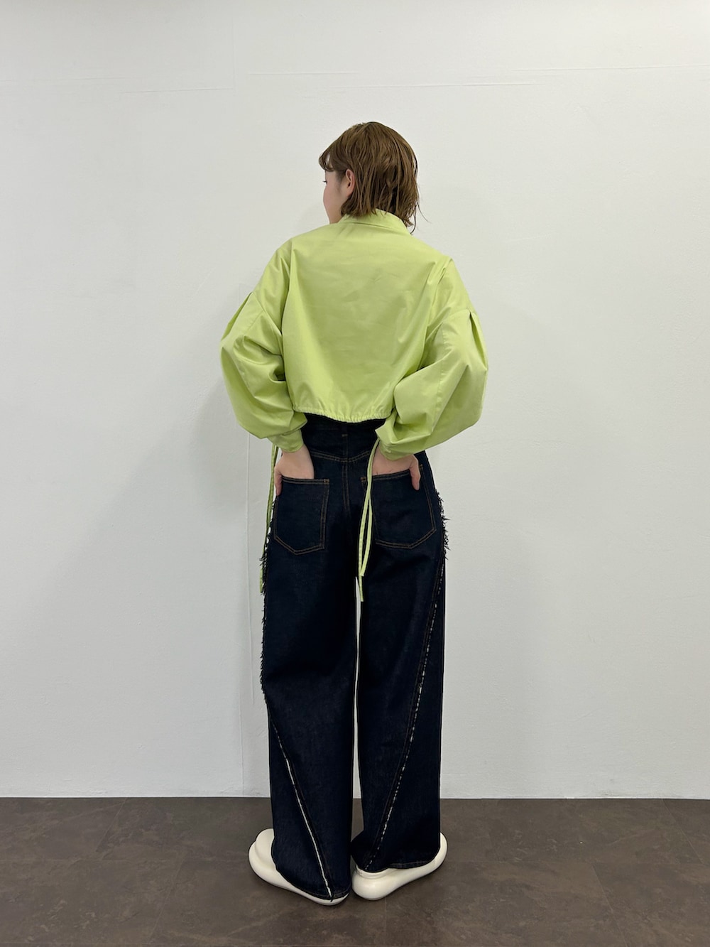 グリーン系のシャツ/ブラウス、ホワイト系のその他シューズ、ブルー系のデニムパンツを着用したレディースの春コーディネートの2枚目の写真