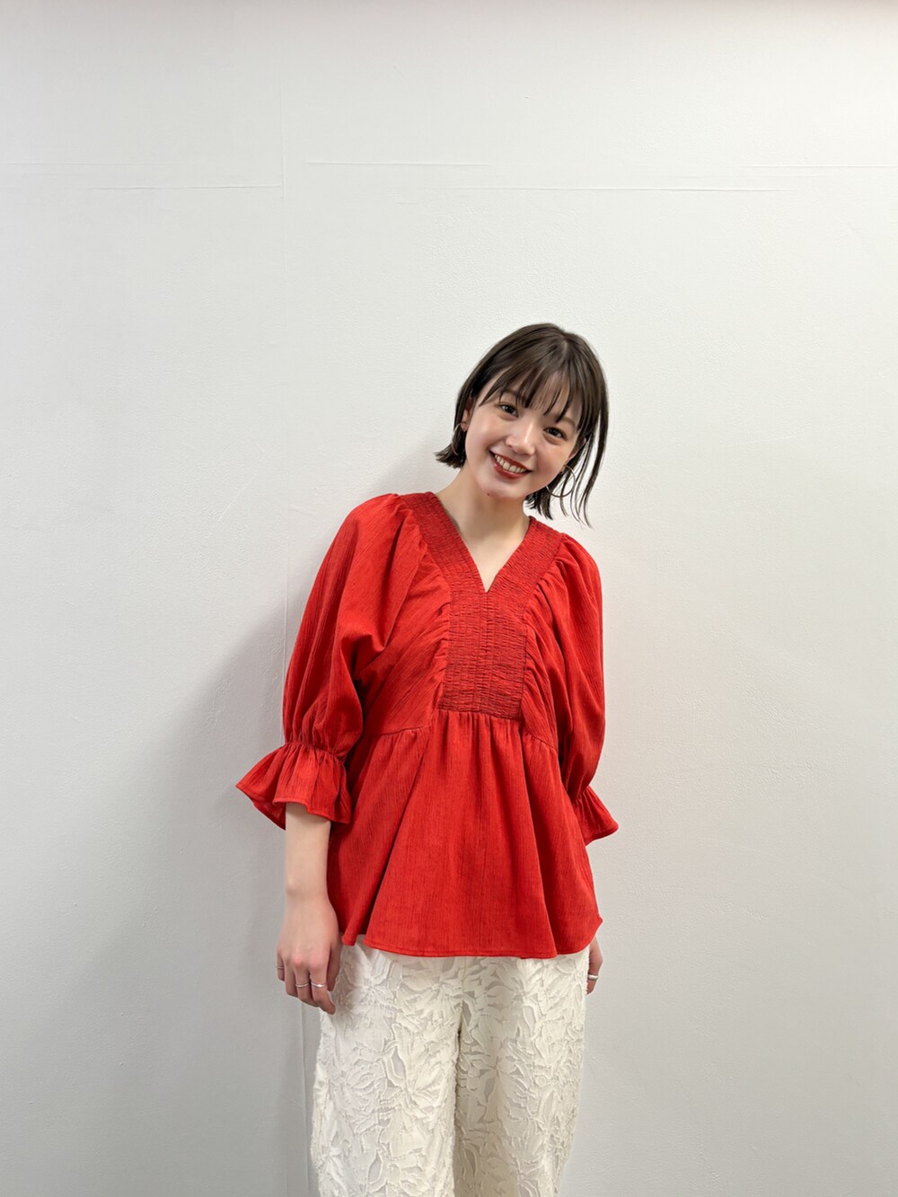 ホワイト系のその他パンツ、ベージュ系のその他シューズ、レッド系のシャツ/ブラウスを着用したレディースの春コーディネートの3枚目の写真