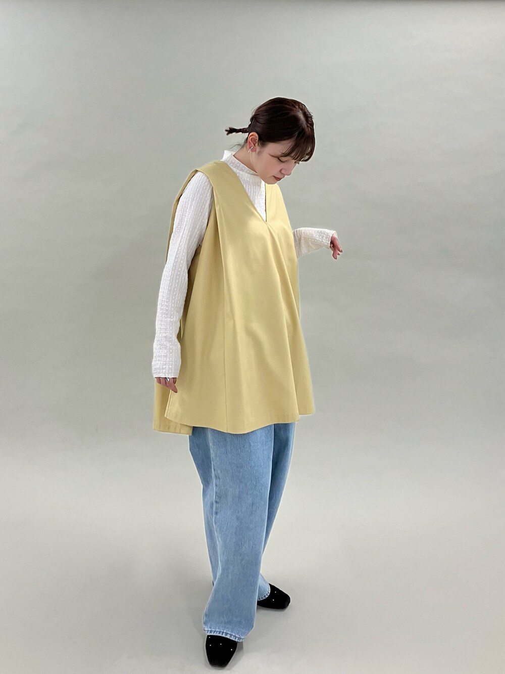 ブルー系のデニムパンツ、ブラウン系のパンプス、ベージュ系のワンピースを着用したレディースの夏コーディネートの3枚目の写真