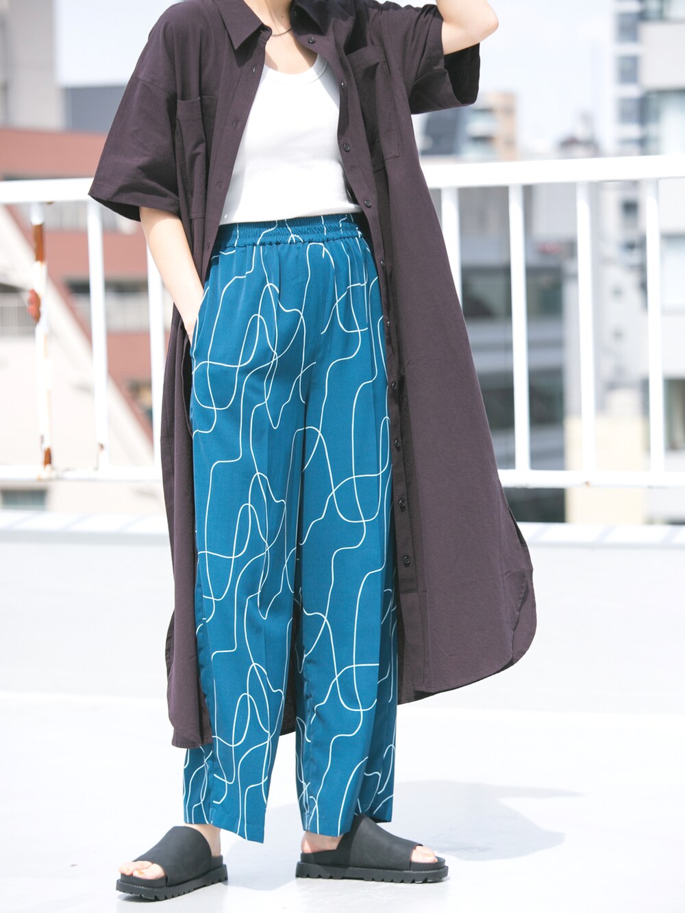 ブラック系のサンダル、ブラウン系のワンピース、ブルー系のその他パンツを着用したレディースの夏コーディネートの3枚目の写真