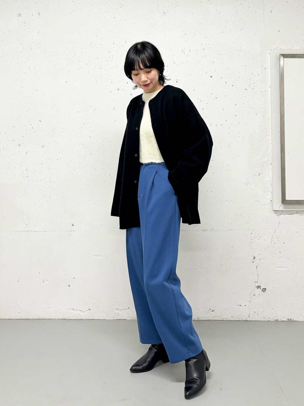 ブルー系のその他パンツ、ブラック系のノーカラージャケット、ホワイト系のニット/セーターを着用したレディースの冬コーディネートの2枚目の写真