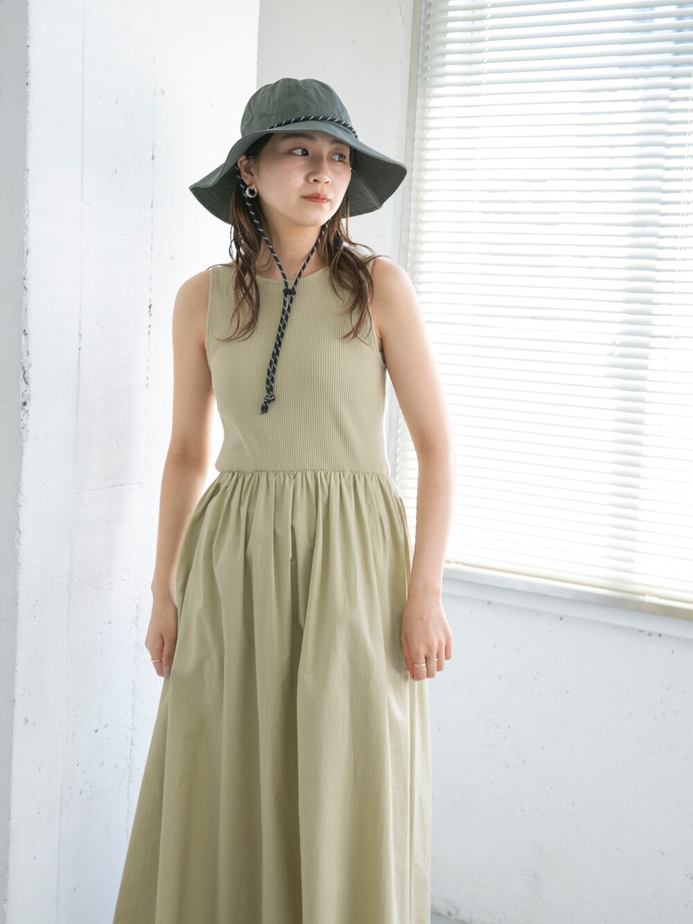 ベージュ系のワンピース、ブラック系のサンダル、グレー系のハットを着用したレディースの夏コーディネートの2枚目の写真