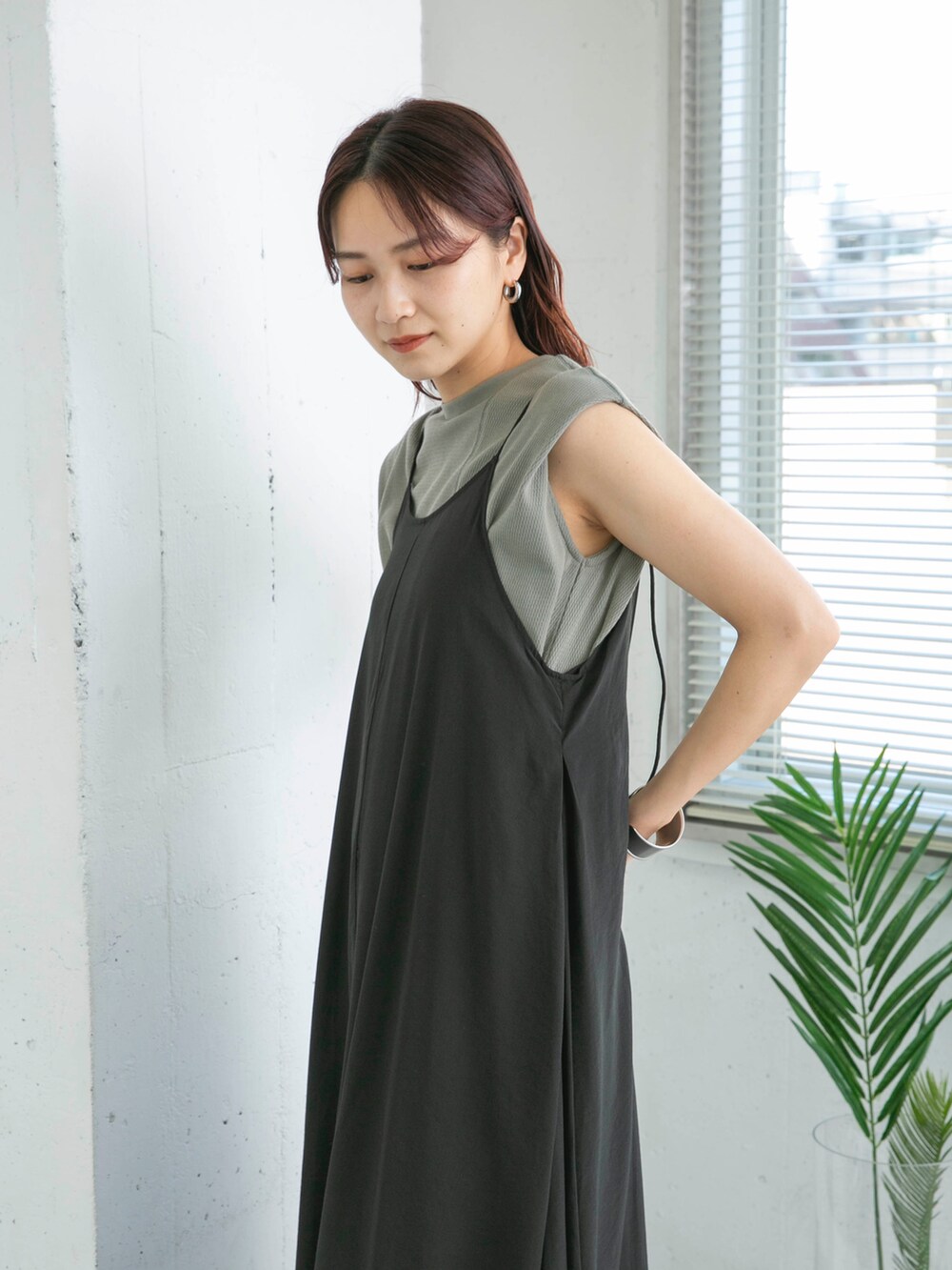 グリーン系のTシャツ/カットソー、ブラック系のワンピース、ブラック系のサンダルを着用したレディースの夏コーディネートの4枚目の写真