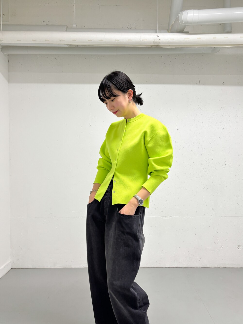 イエロー系のカーディガン/ボレロ、ブラック系のデニムパンツを着用したレディースの冬コーディネートの3枚目の写真