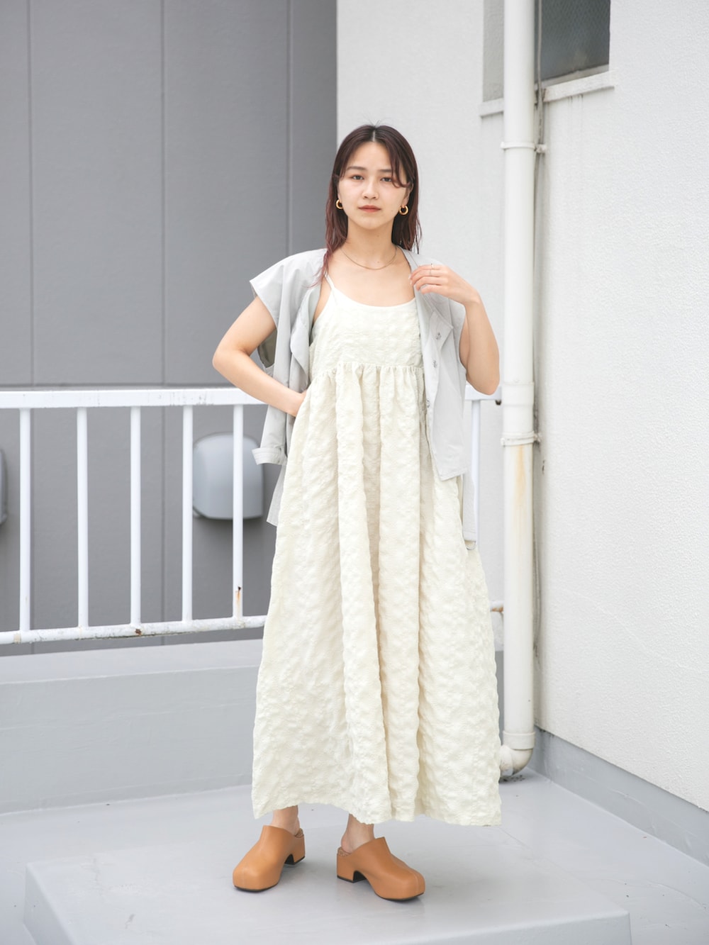 ベージュ系のワンピース、グリーン系のベスト、イエロー系のサンダルを着用したレディースの夏コーディネートの2枚目の写真