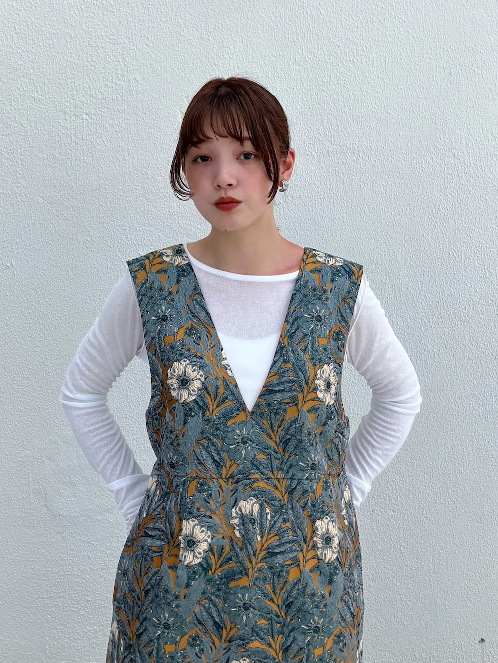 イエロー系のワンピース、ブラック系のブーツを着用したレディースの夏コーディネートの2枚目の写真