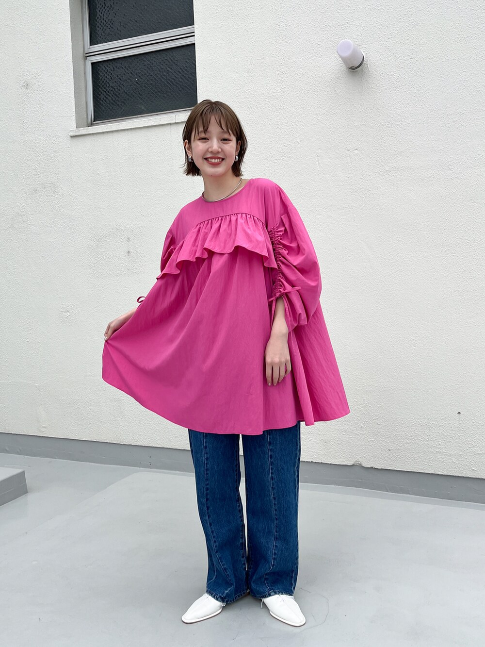 ブルー系のデニムパンツ、ピンク系のワンピース、ホワイト系のその他シューズを着用したレディースの春コーディネートの2枚目の写真