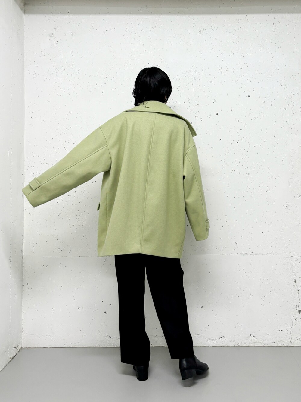 ブラック系のステンカラーコート、ベージュ系のニット/セーター、グリーン系のその他パンツを着用したレディースの冬コーディネートの2枚目の写真