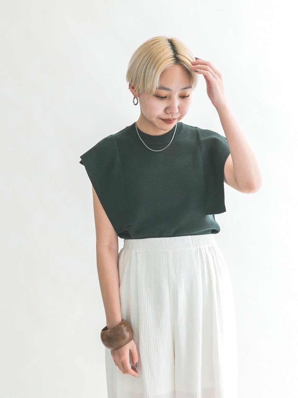 ブラック系のサンダル、グリーン系のニット/セーター、ホワイト系のその他パンツを着用したレディースの夏コーディネートの4枚目の写真