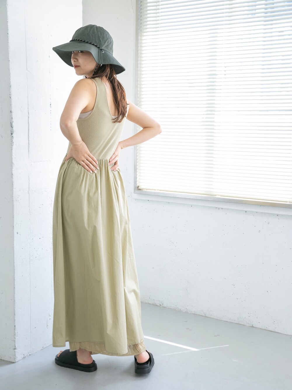 ベージュ系のワンピース、ブラック系のサンダル、グレー系のハットを着用したレディースの夏コーディネートの4枚目の写真