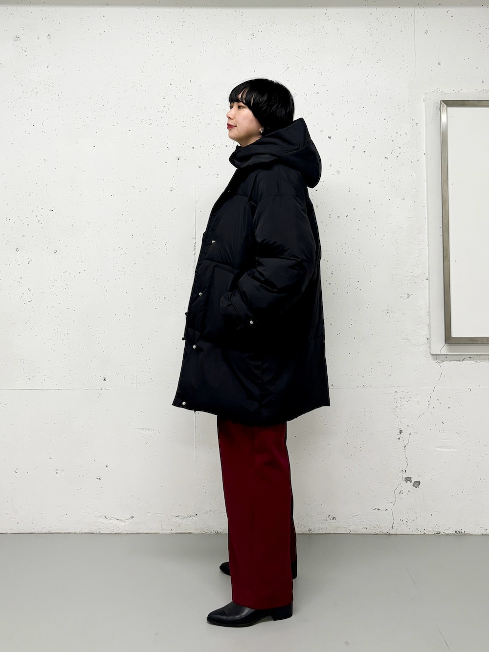 ブラック系のダウンジャケット/コート、ブルー系のニット/セーター、ホワイト系のTシャツ/カットソーを着用したレディースの冬コーディネートの3枚目の写真