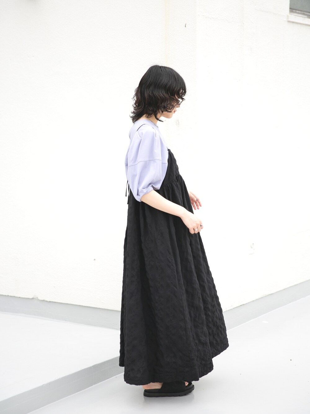 ブラック系のサンダル、ブラック系のワンピース、パープル系のTシャツ/カットソーを着用したレディースの夏コーディネートの2枚目の写真