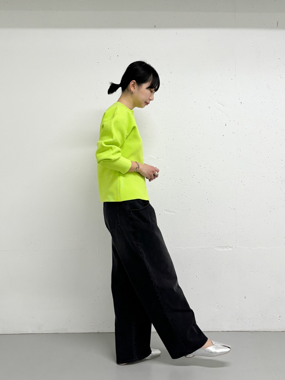 イエロー系のカーディガン/ボレロ、ブラック系のデニムパンツを着用したレディースの冬コーディネートの2枚目の写真