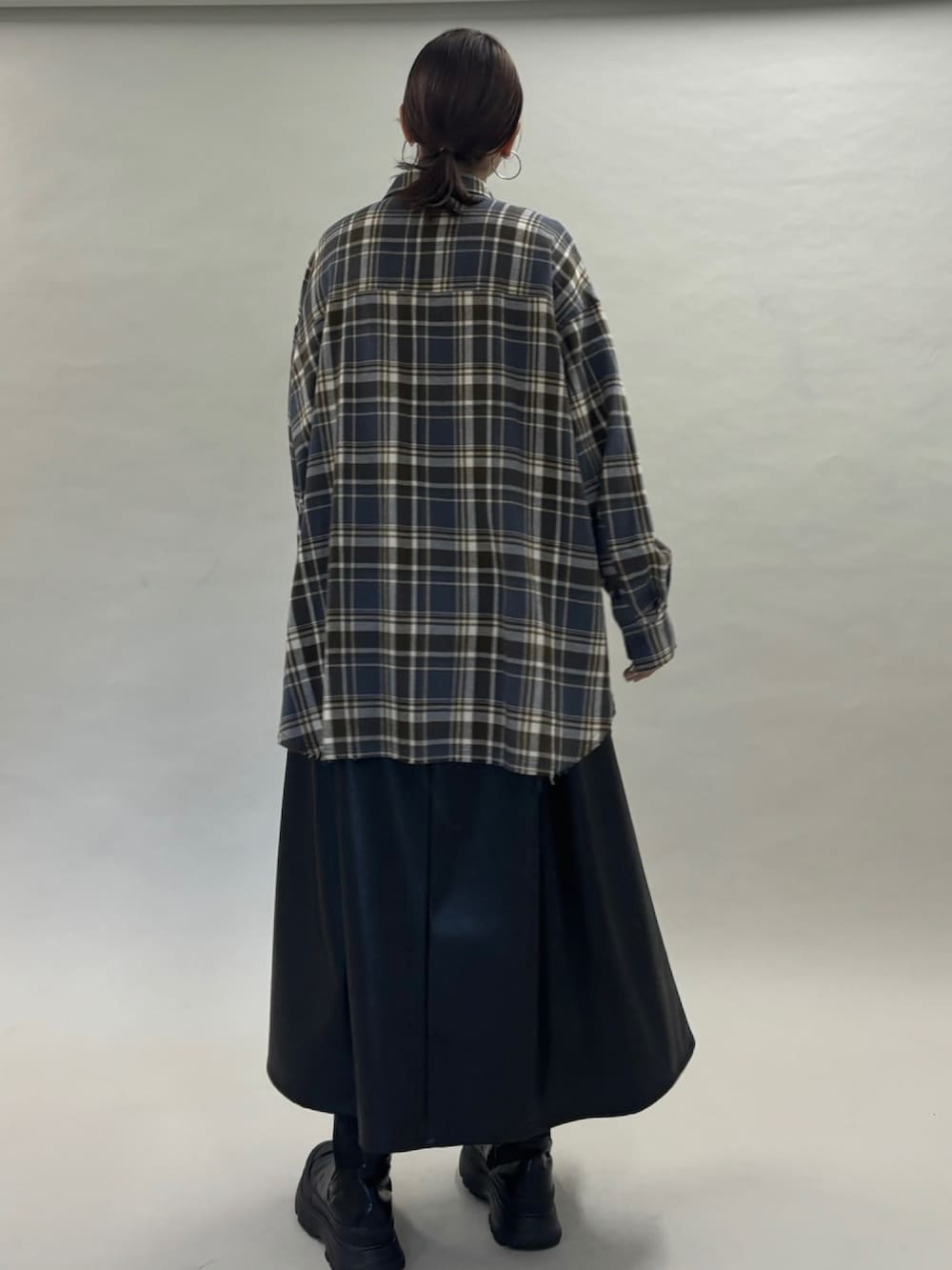 グレー系のシャツ/ブラウス、ブラック系のスカート、ブラック系のブーツを着用したレディースの秋コーディネートの4枚目の写真