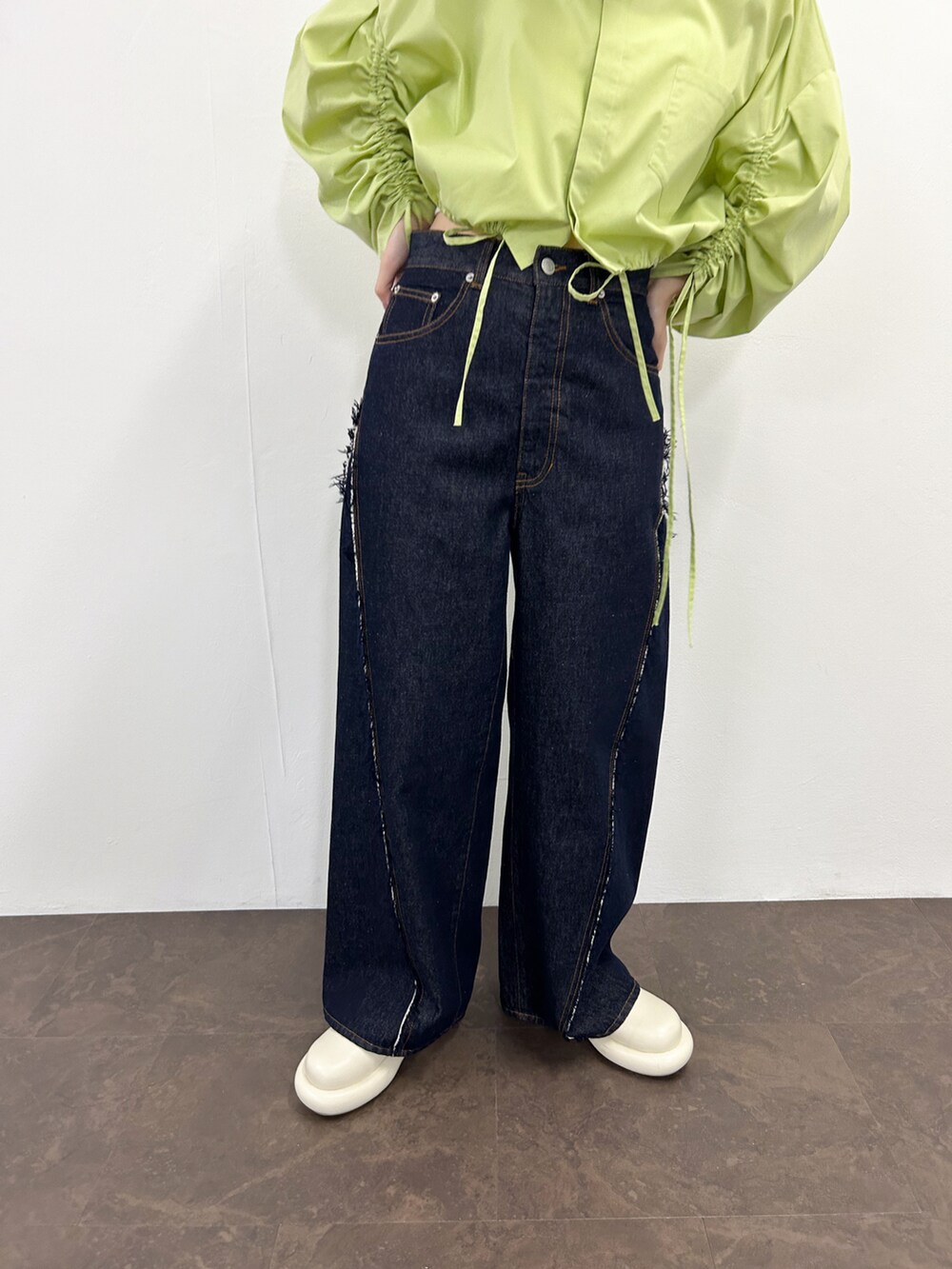 グリーン系のシャツ/ブラウス、ホワイト系のその他シューズ、ブルー系のデニムパンツを着用したレディースの春コーディネートの4枚目の写真