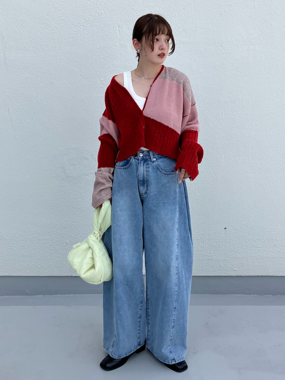 レッド系のニット/セーター、ブラック系のその他シューズ、ブルー系のデニムパンツを着用したレディースの夏コーディネートの2枚目の写真