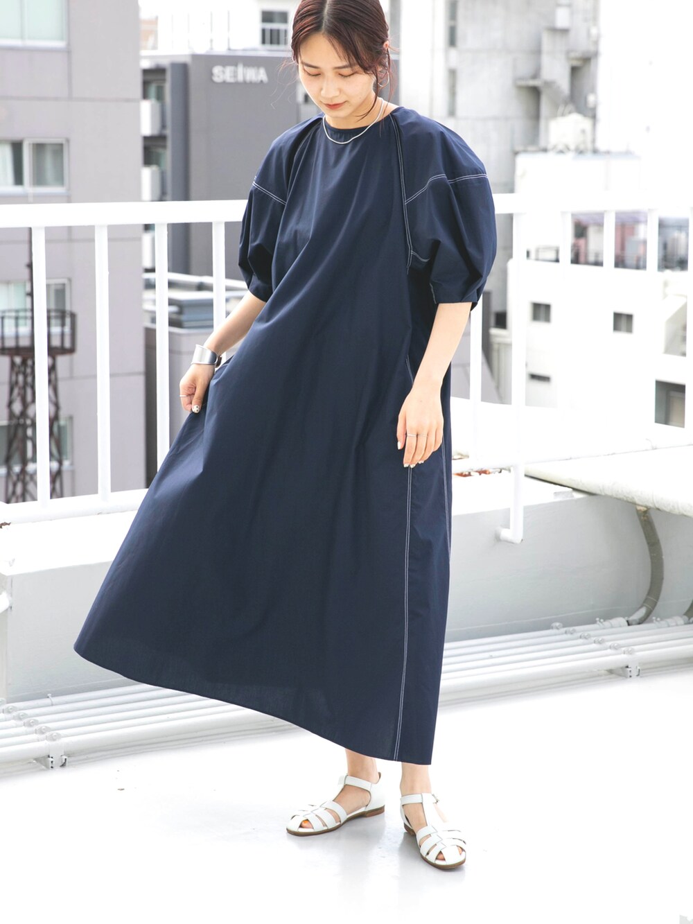 ホワイト系のサンダル、ブルー系のワンピースを着用したレディースの夏コーディネートの2枚目の写真
