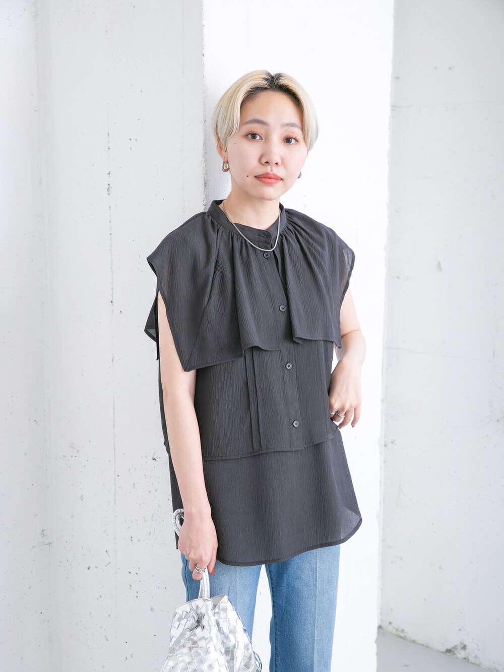 ブラック系のシャツ/ブラウス、ブルー系のデニムパンツ、シルバー系のショルダーバッグを着用したレディースの夏コーディネートの4枚目の写真