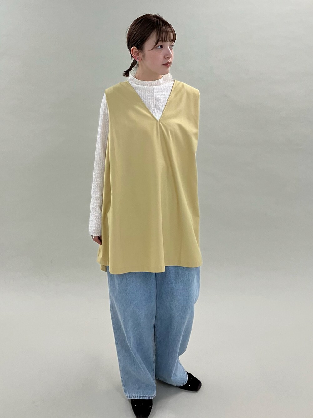 ブルー系のデニムパンツ、ブラウン系のパンプス、ベージュ系のワンピースを着用したレディースの夏コーディネートの2枚目の写真